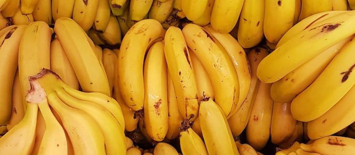 yellow banana fruit on brown wooden table